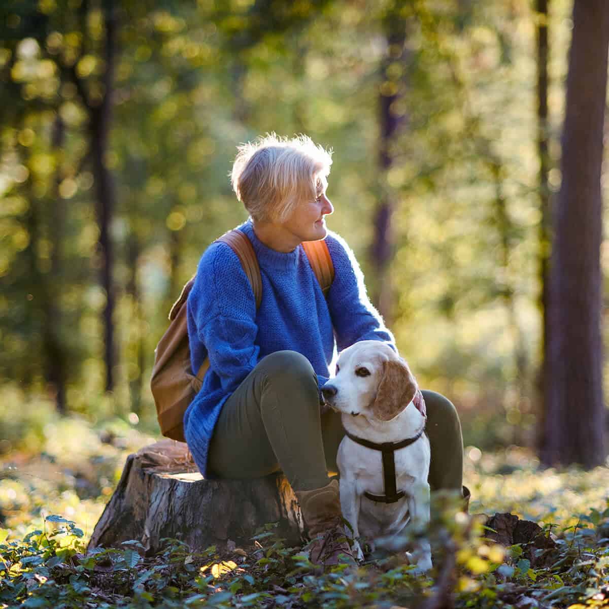 Senior Woman with her dog in the woods